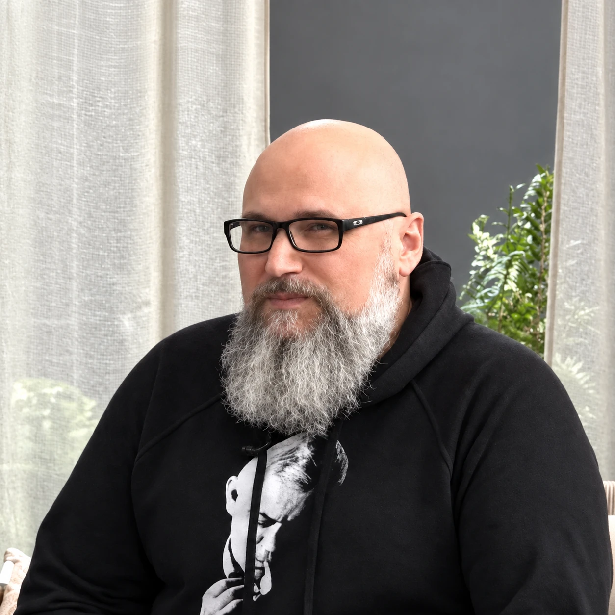 Piotr Walas w okularach i czarnej bluzie, z siwą brodą
